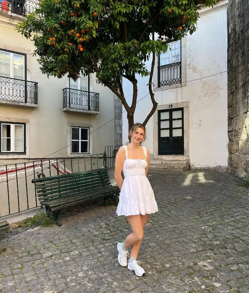 White Smocked Sundress with Athletic Sneakers in a Historic European Square