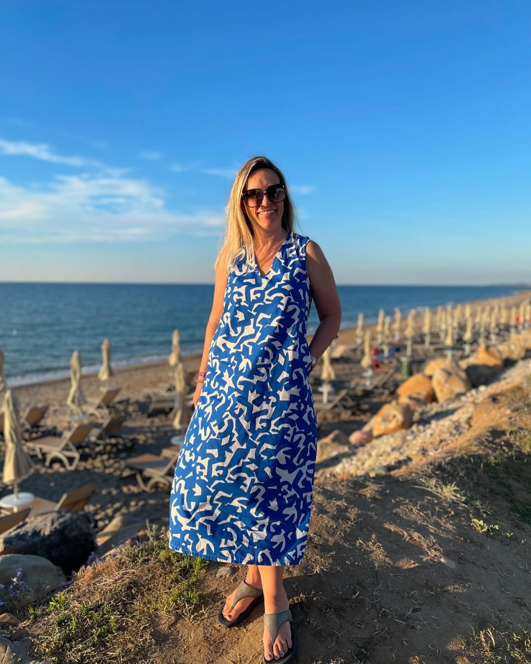 Abstract Blue and White Shift Dress with Dark Grey Flip-Flops on the Coast