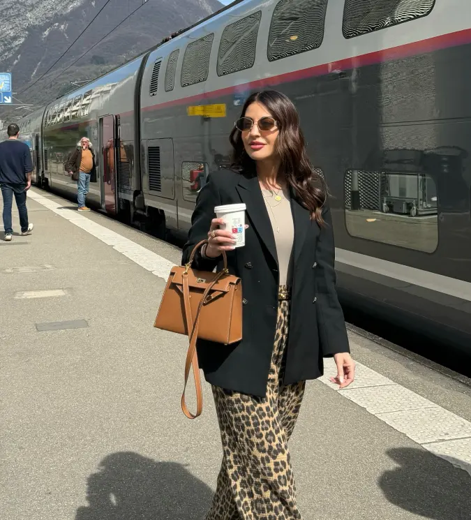 Black Blazer with Beige Top and Leopard Trousers on a Mountain Train Platform