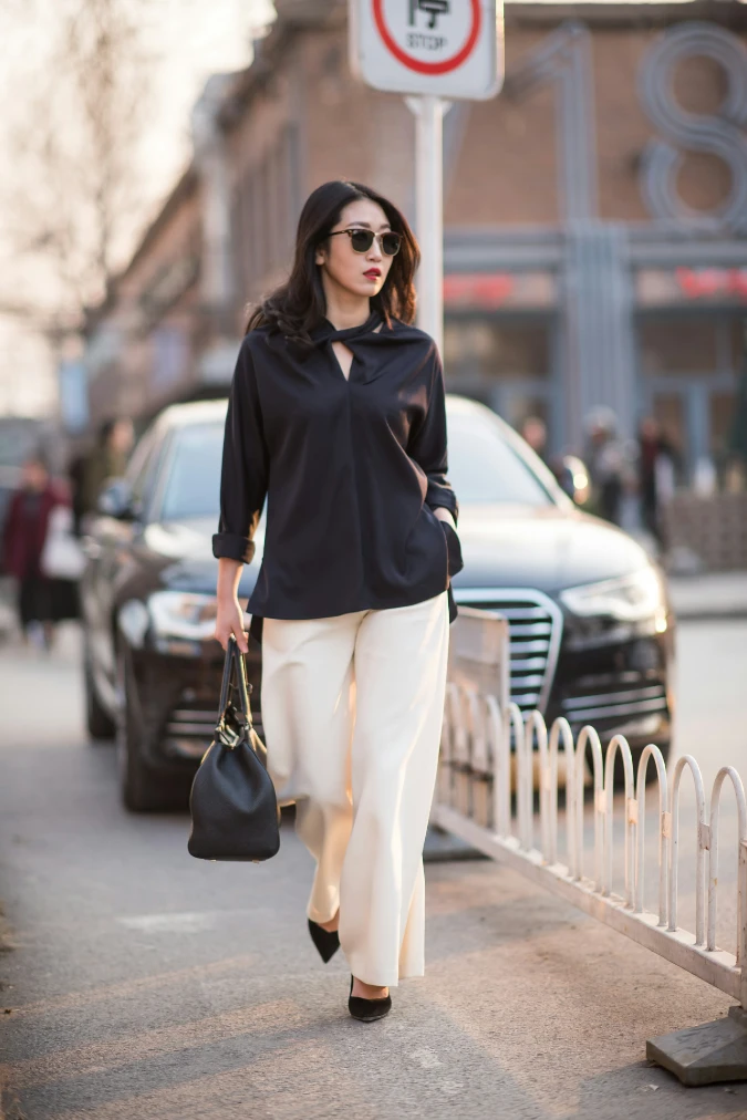  Black Silk Blouse with Cream Trousers and Structured Handbag on City Walk