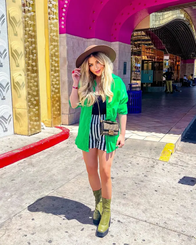 Green Oversized Shirt with Striped Shorts Under a Pink Casino Arch