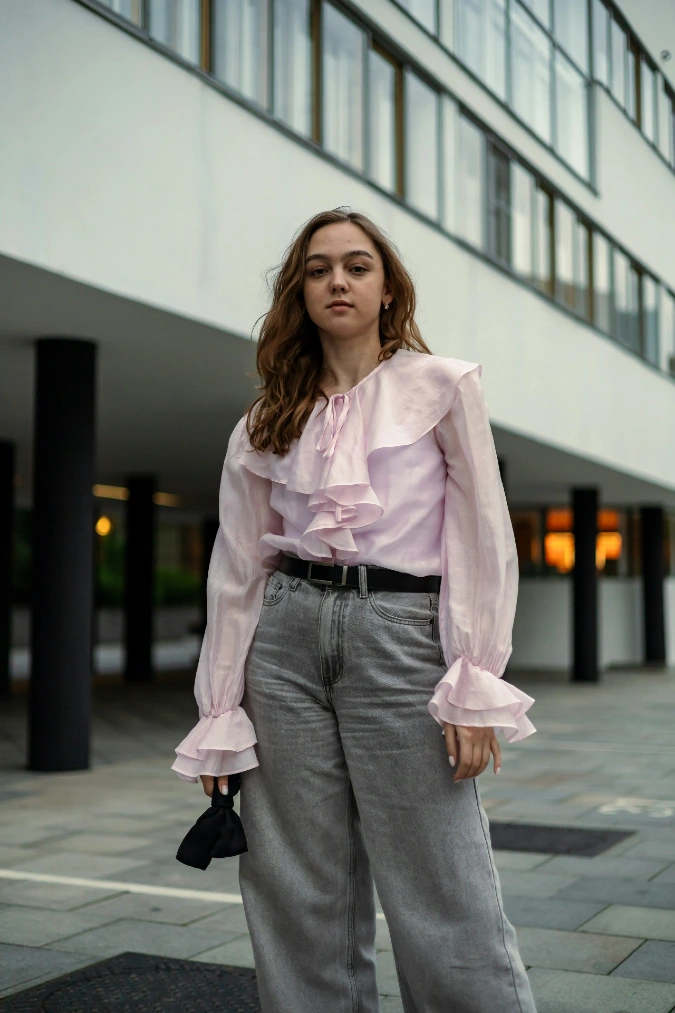 Soft Pink Ruffle Blouse with Grey Wide-Leg Trousers and Belted Minimal Finish