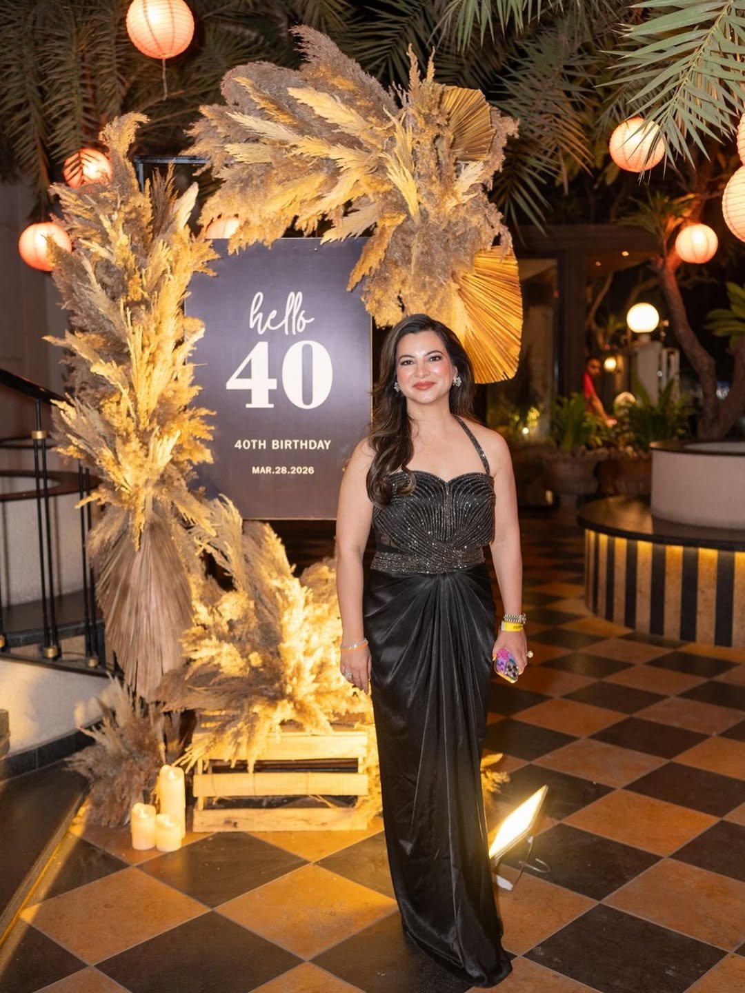 Sparkling Black Halter Gown with Draped Satin Skirt beside Boho Birthday Sign