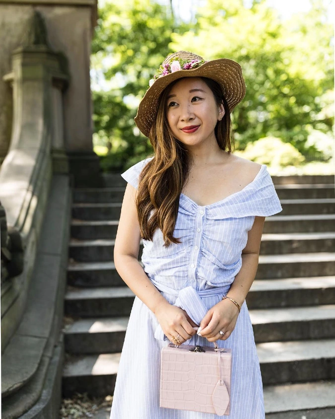 Straw Hat Floral Accent with Soft Blue Striped Dress on Stone Steps
