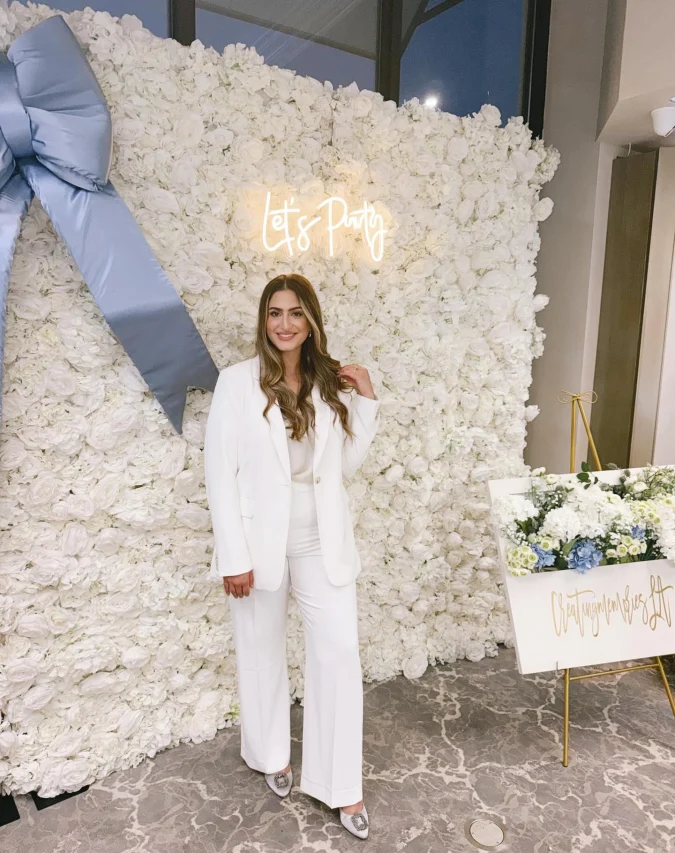  White Power Suit Against Floral Wall with Soft Blue Bow Installation