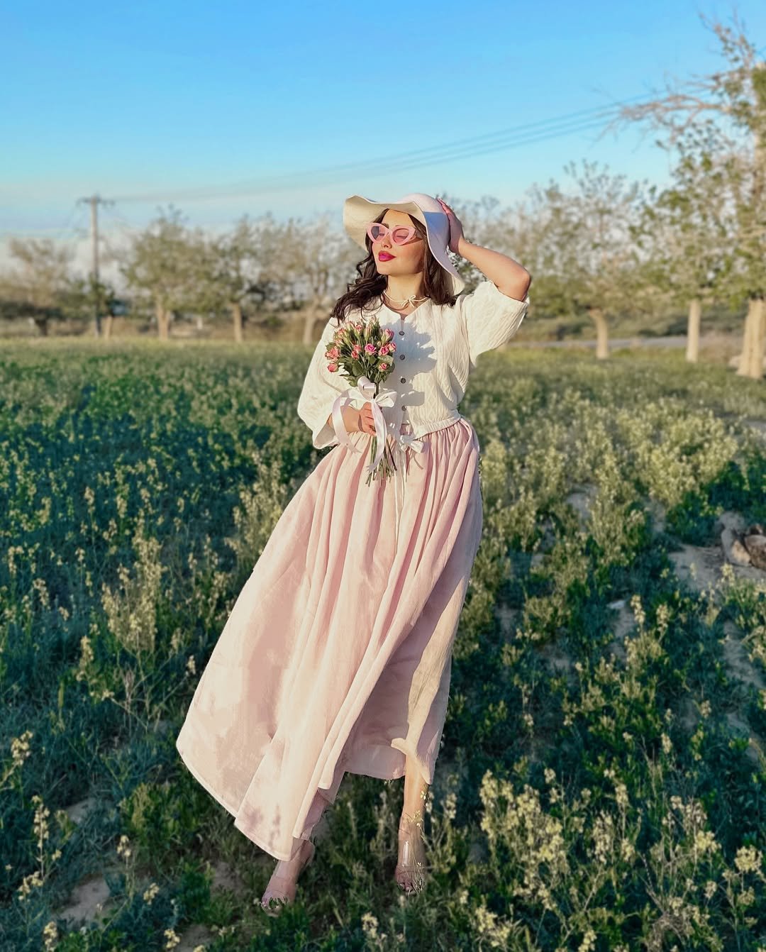 White Textured Blouse with a Flowing Blush Skirt and Wide Brimmed Hat