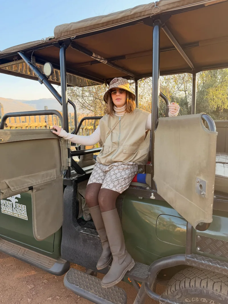 Beige Utility Vest over Turtleneck with Monogram Shorts and Tall Boots