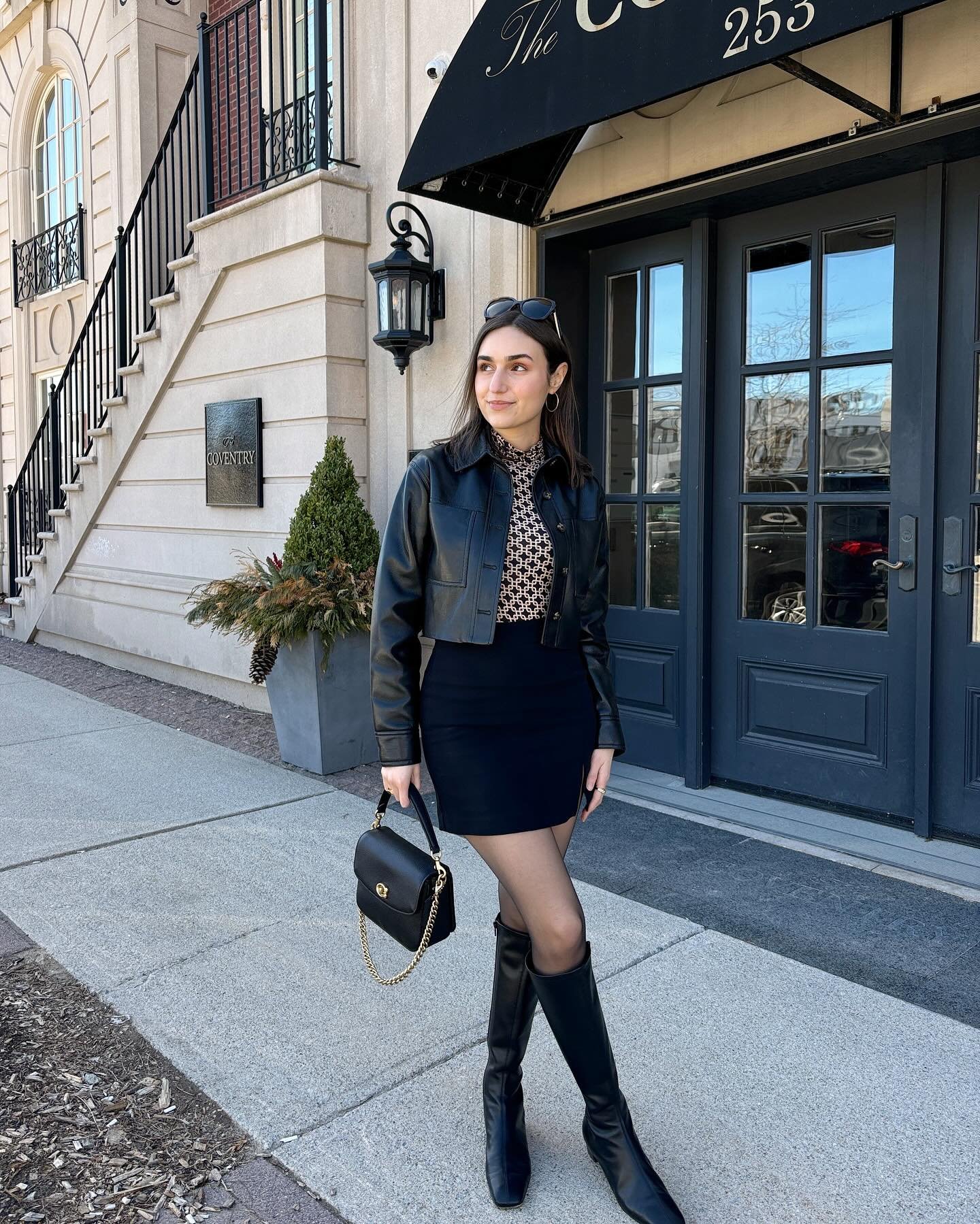 Cropped Black Leather Jacket with Patterned Mock-Neck Top and Fitted Mini Skirt Display