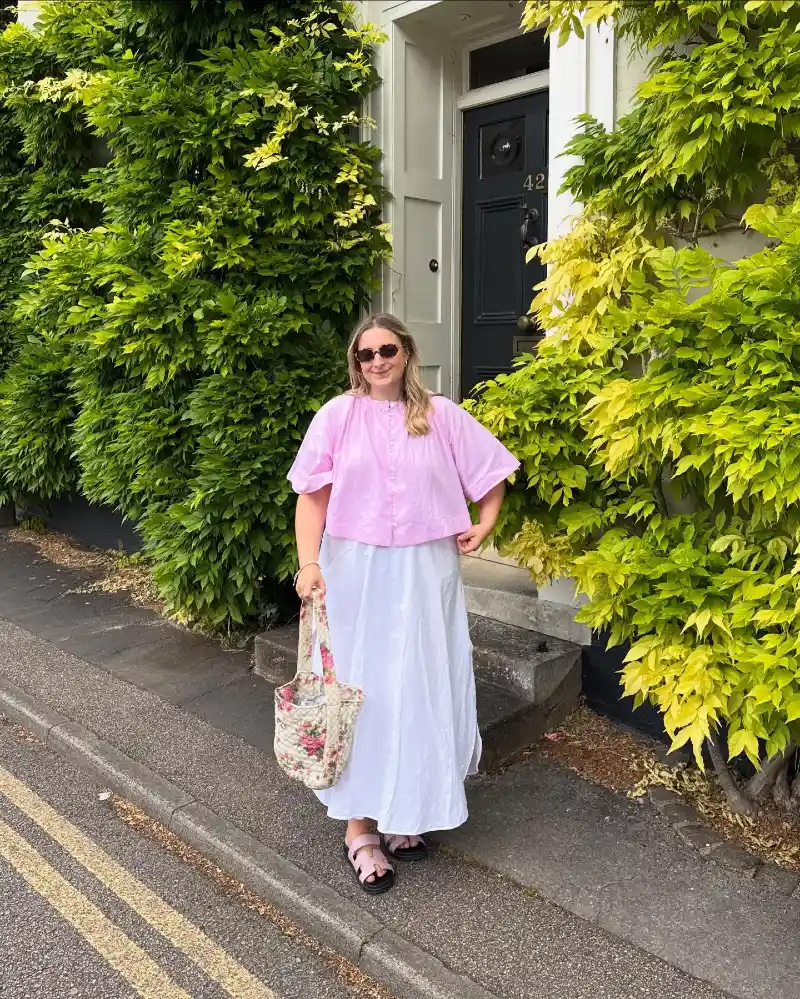 Cropped Pink Linen Blouse with a Voluminous White Maxi Skirt and Floral Quilted Tote