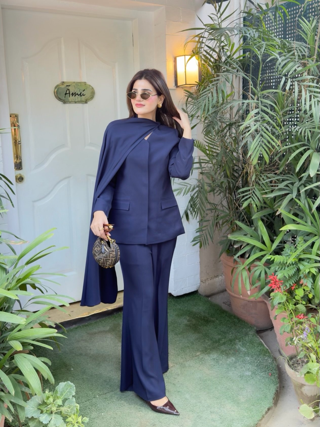 Navy Tailored Suit with Asymmetrical Shoulder Drape and Patterned Handbag