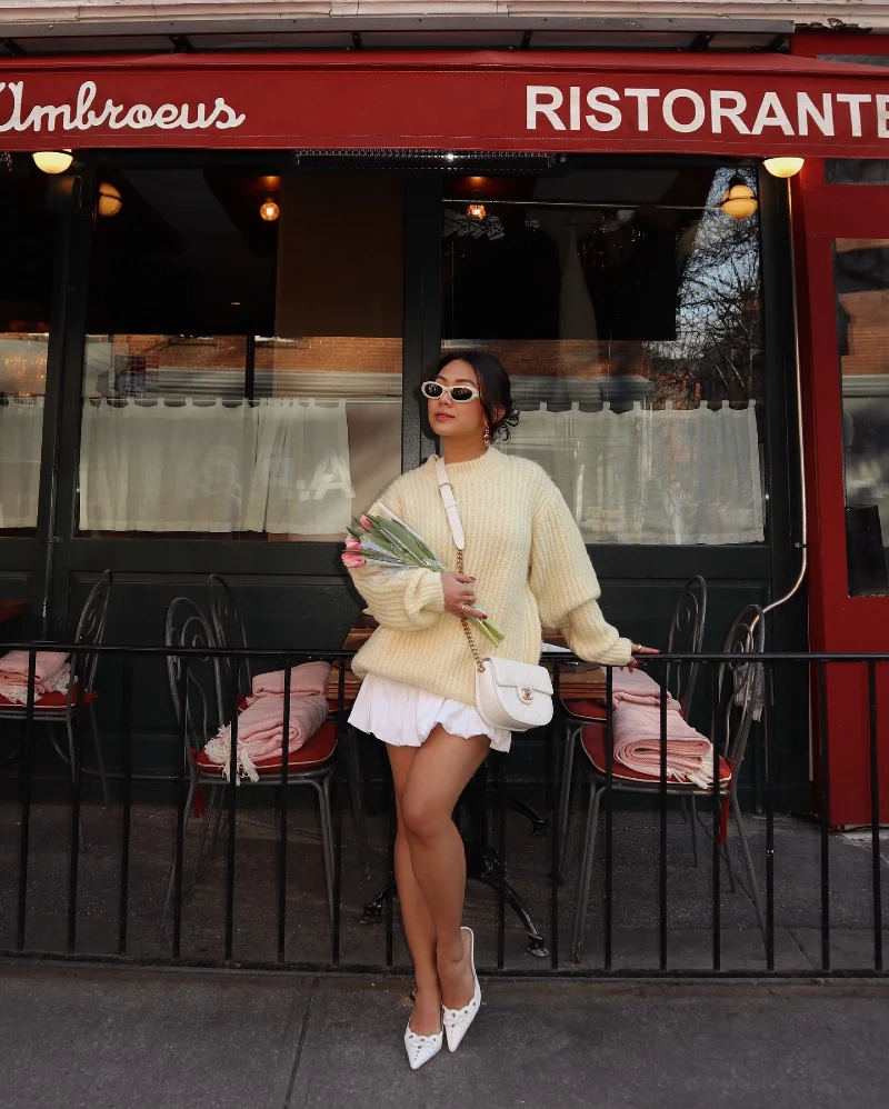 Oversized Cream Ribbed Sweater with White Pleated Mini Skirt and Pointed Mules