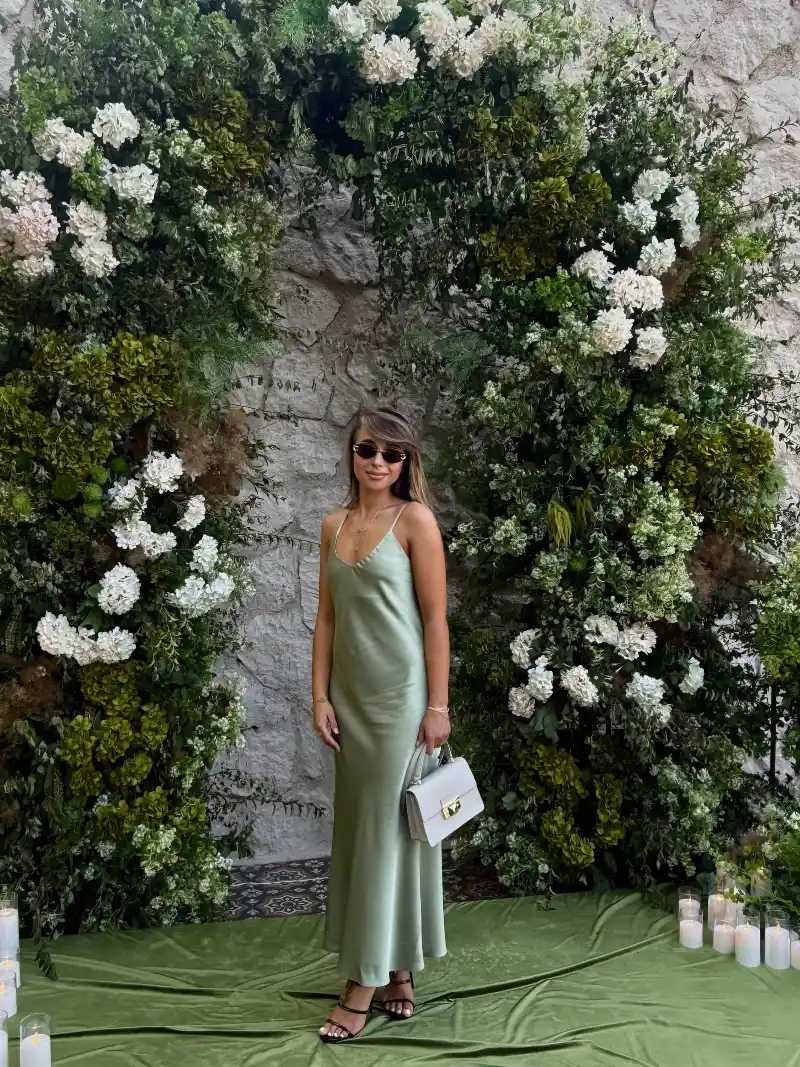 Sage Green Satin Slip Dress with Black Heels and Lush White Floral Arch