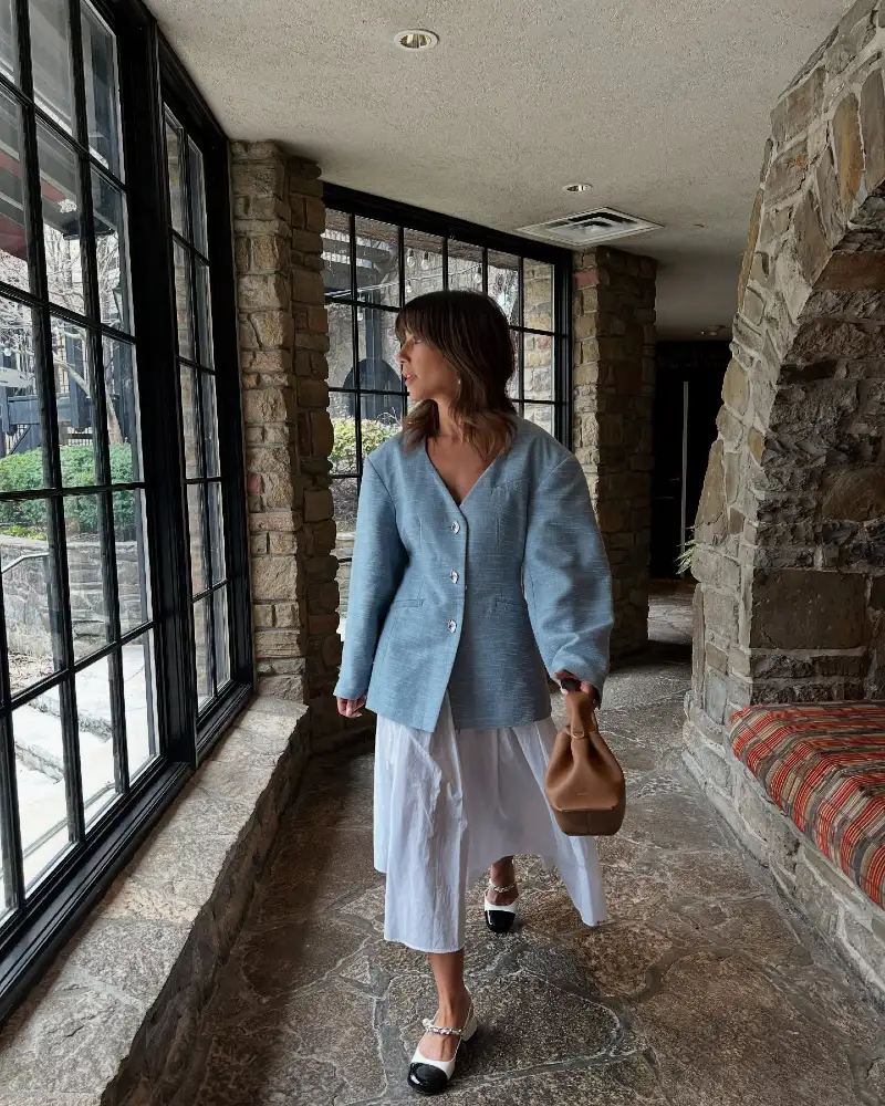 Structured Slate Blue Blazer Layered Over a White Cotton Dress in a Stone Hallway