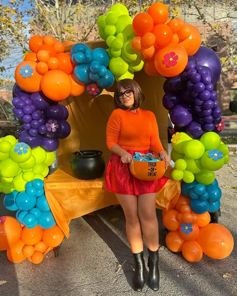 Bright Orange Long-Sleeve Turtleneck with Red Pleated Mini Skirt and Glasses