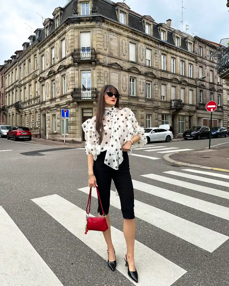 Sheer Ruffled Organza Dot Blouse with Tailored Capri Pants and Statement Red Bag